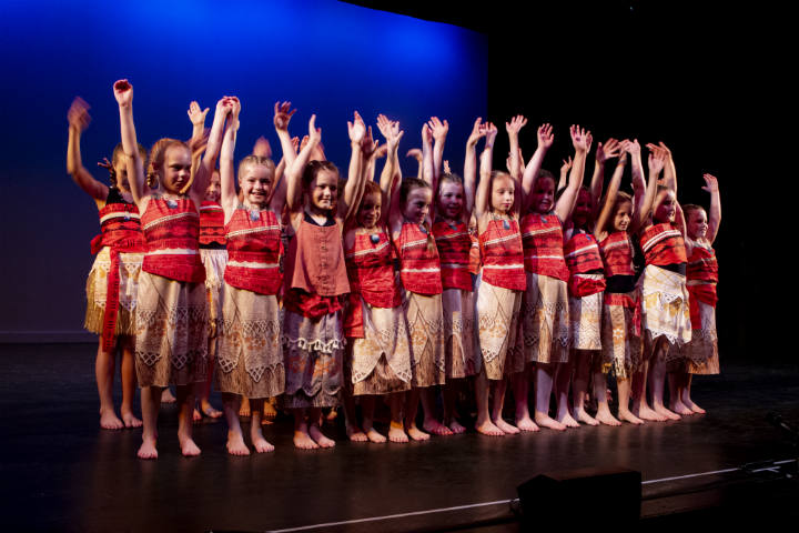 Young performers in togas with brightly coloured sashes.