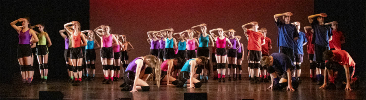 Male and female dancers flexing their biceps or holding the plank position.